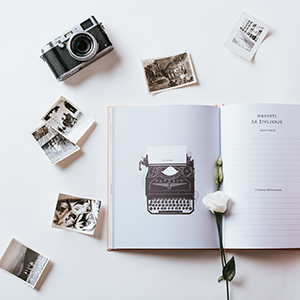 Odprta knjiga s fotografijami in fotoaparatom
